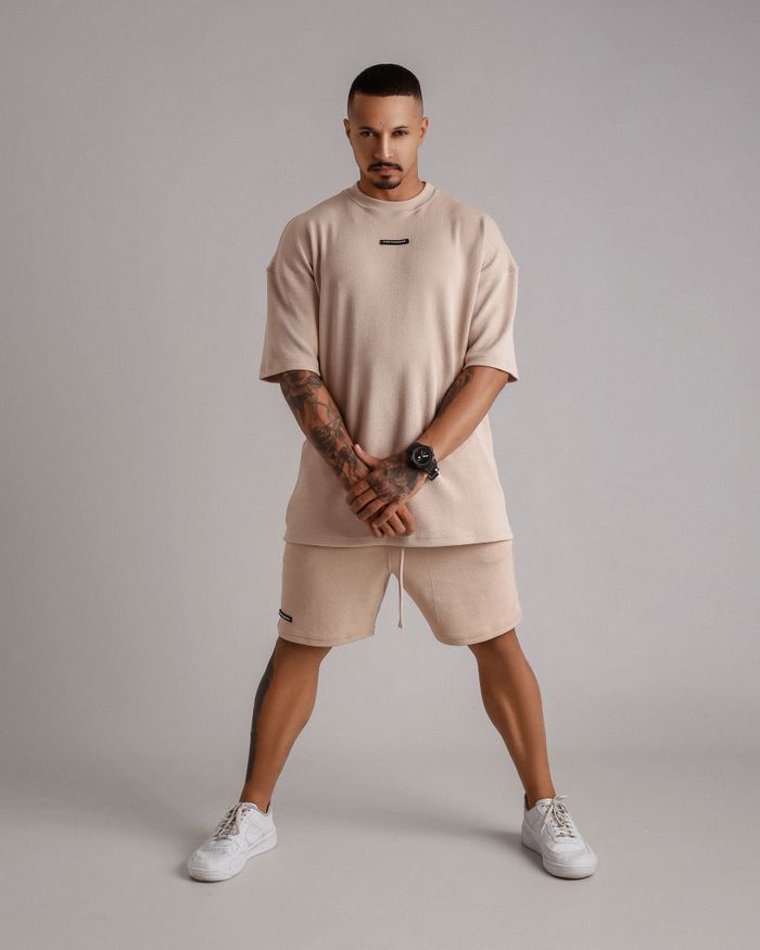 Fashion model posing in stylish beige outfit during studio shoot.